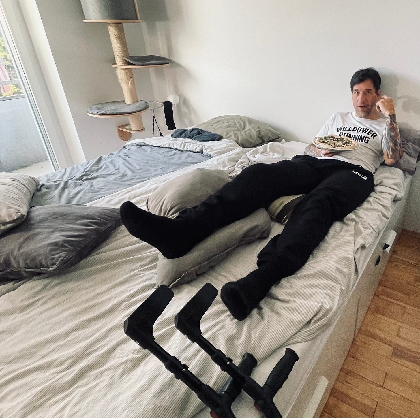 The author lying in his bed with a splint and crutches