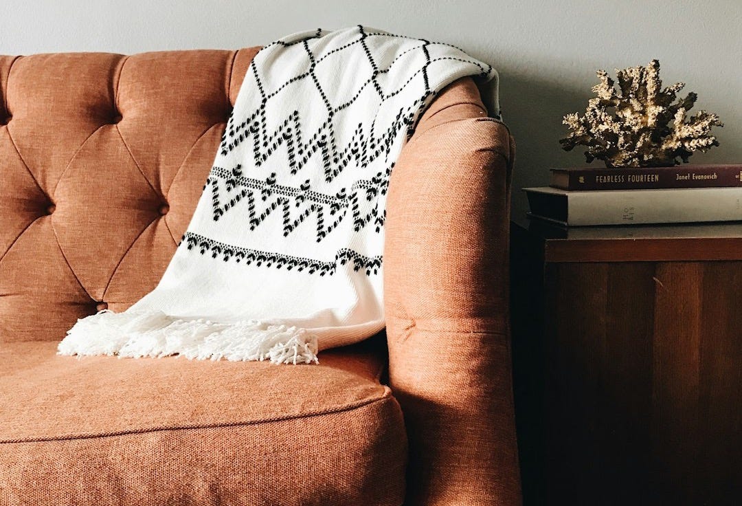 white and black textile on brown couch