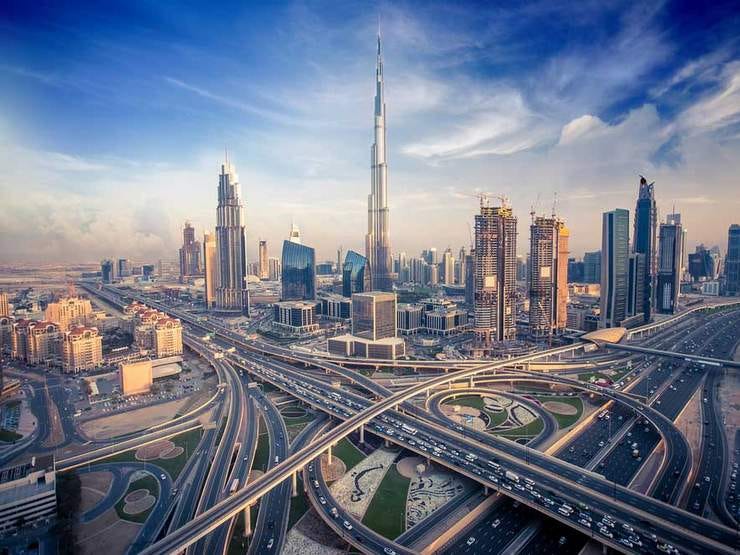 Photo of the Sheikh Zayed road highway in Dubai, UAE surrounded by skyscrapers under a morning sky with a few clouds passing by Photo of the Sheikh Zayed road highway in Dubai, UAE surrounded by skyscrapers under a morning sky with a few clouds passing by