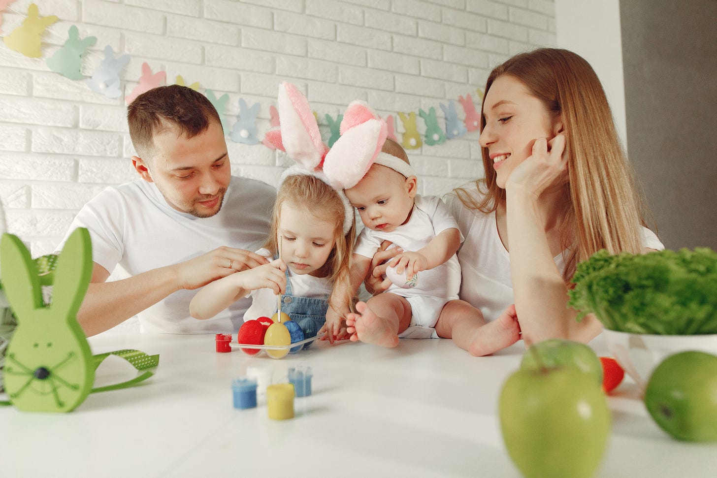 Family with two kids in a kitchen preparing to easter