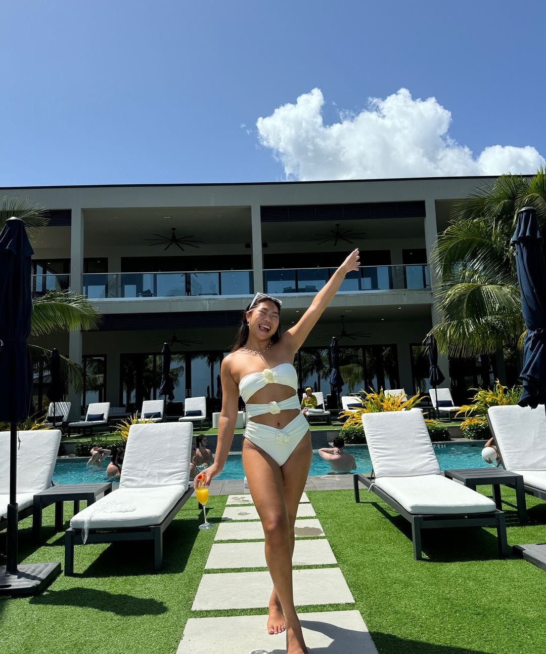 TikToker Mei Mei standing in front of a swimming pool in the Cayman Islands