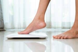 woman's foot touching bathroom scale