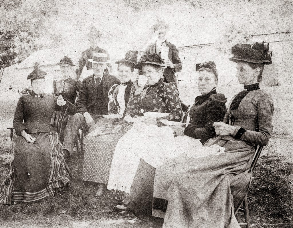 Group of women seated outdoors enjoying tea