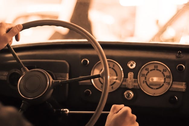 Premium Photo | Driving a vintage car; only the driverã¢â€â™s hand on the  steering wheel are visible, the dashboard is blurred; stylized as an old  sepia photo with dust and noise