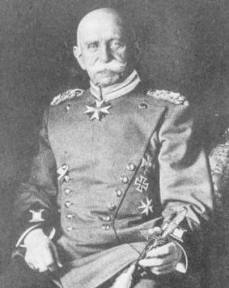 A black and white photo Count Ferdinand von Zeppelin in later years. He is the very model of a modern Prussian gentlemen, with bushy turned up moustache, iron crosses galore and sword in hand.