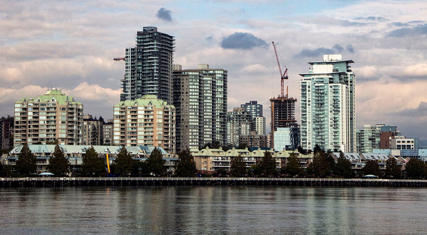 Photo of downtown new westminster. a series of towers, highrises and mid-rises stand over the fraser river.