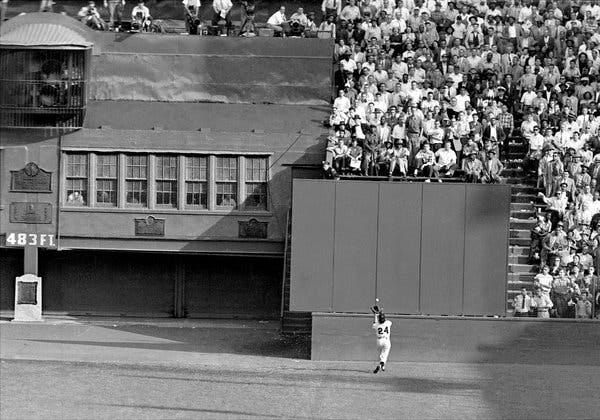 Willie Mays makes an over the shoulder catch near the outfield wall.