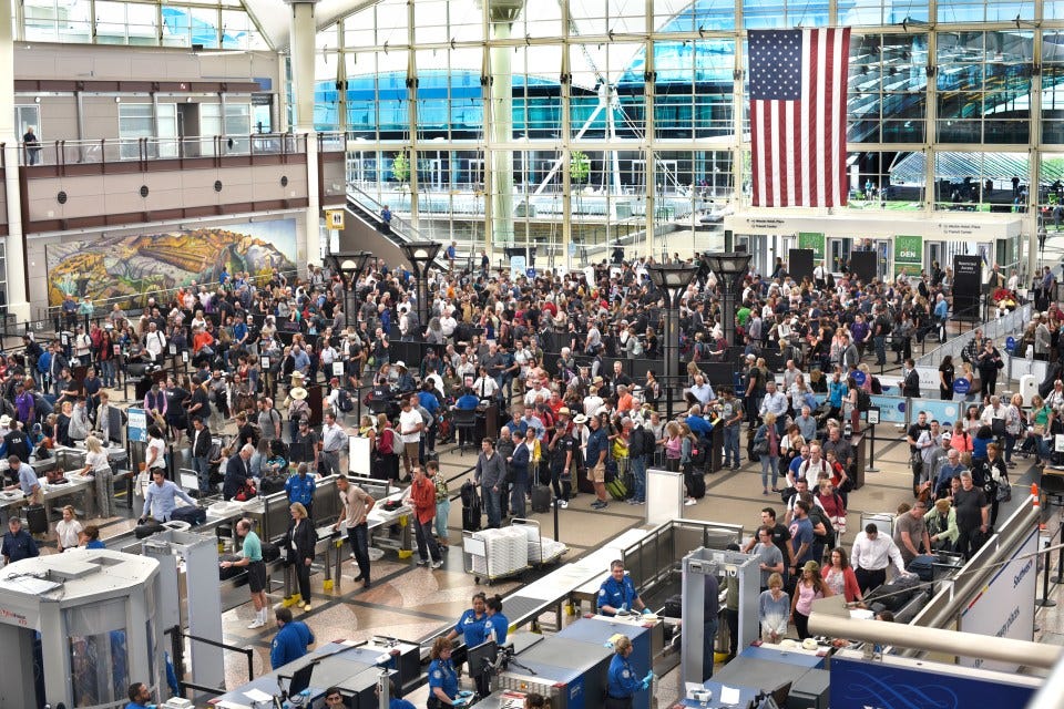 Large crowd of people waiting in line for TSA security at an airport.