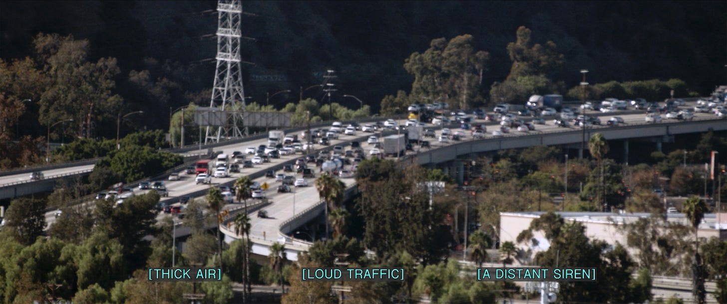 A still image of a congested highway. Lower-third captions in all-caps: THICK AIR, LOUD TRAFFIC, A DISTANT SIREN.