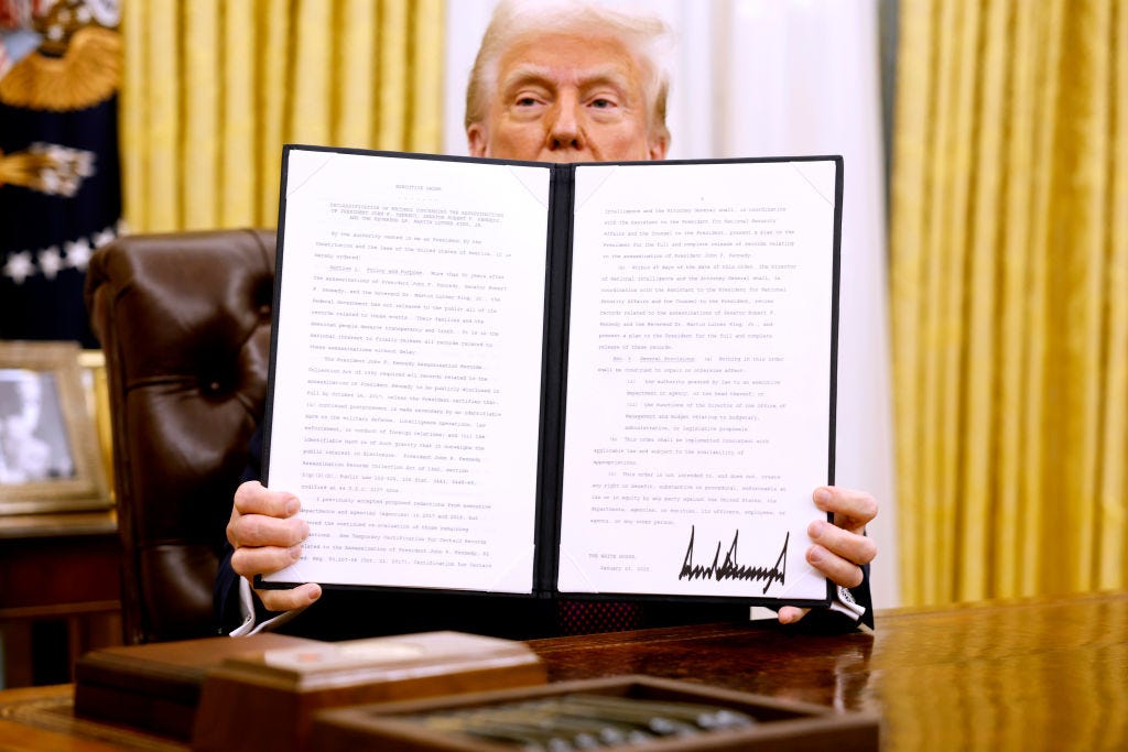 Donald Trump, peering over an executive order