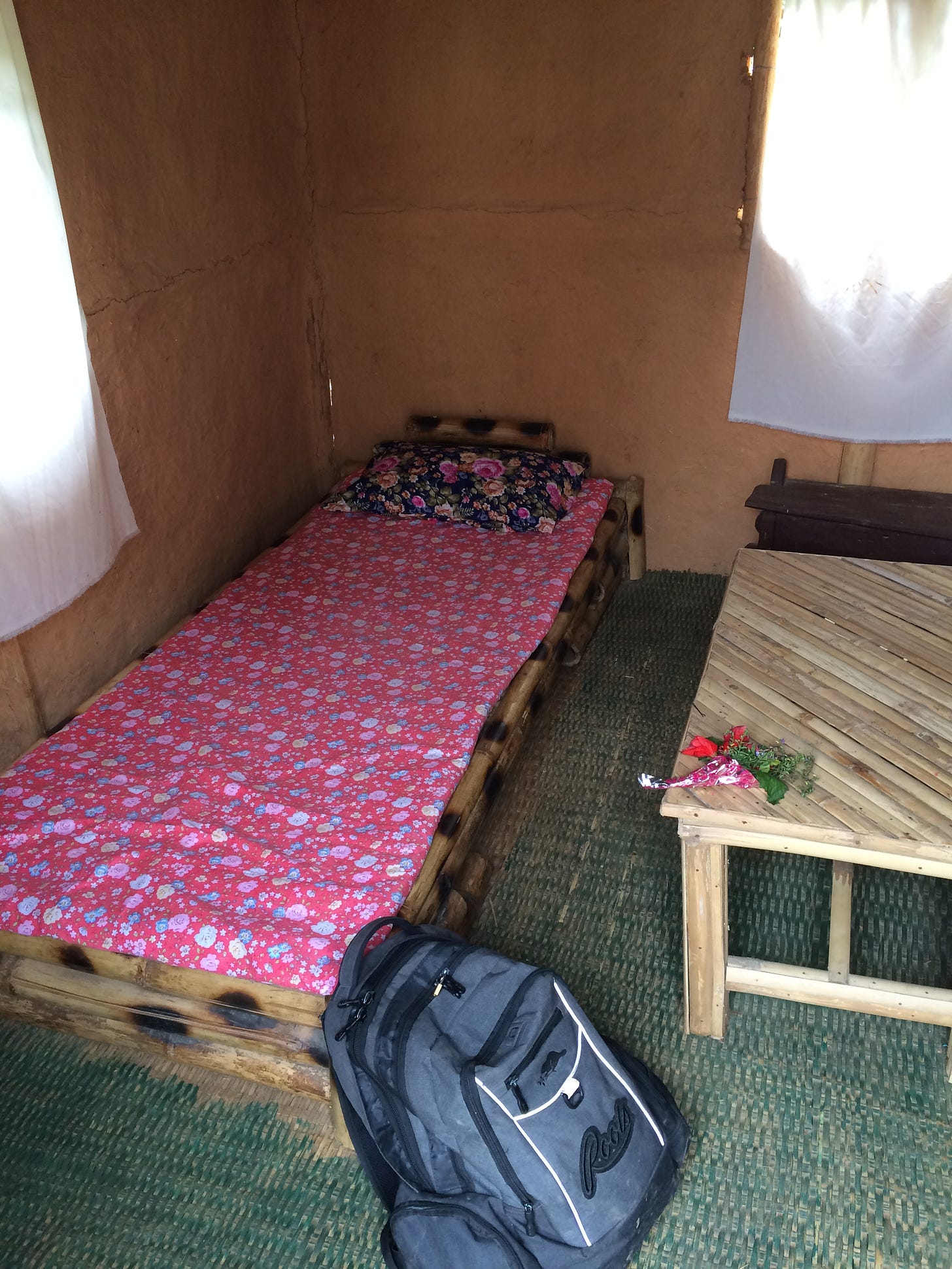 Bed on bamboo frame in red mud hut.