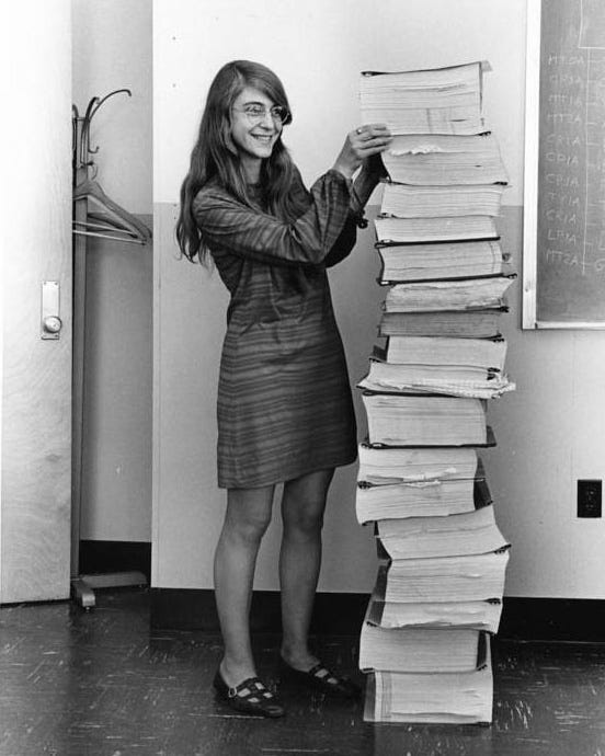 Margaret Hamilton, standing next to the listings of the software she and her MIT team produced for the Apollo project. Source: NASA