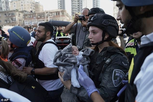 A baby is evacuated from the site of a direct hit from an Iranian missile strike in Ramat Gan, Israel, Thursday, June 19