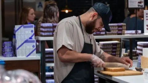 Getty Images A man makes deserts at a store at Chelsea Market in Manhattan on February 02, 2024 in New York City.