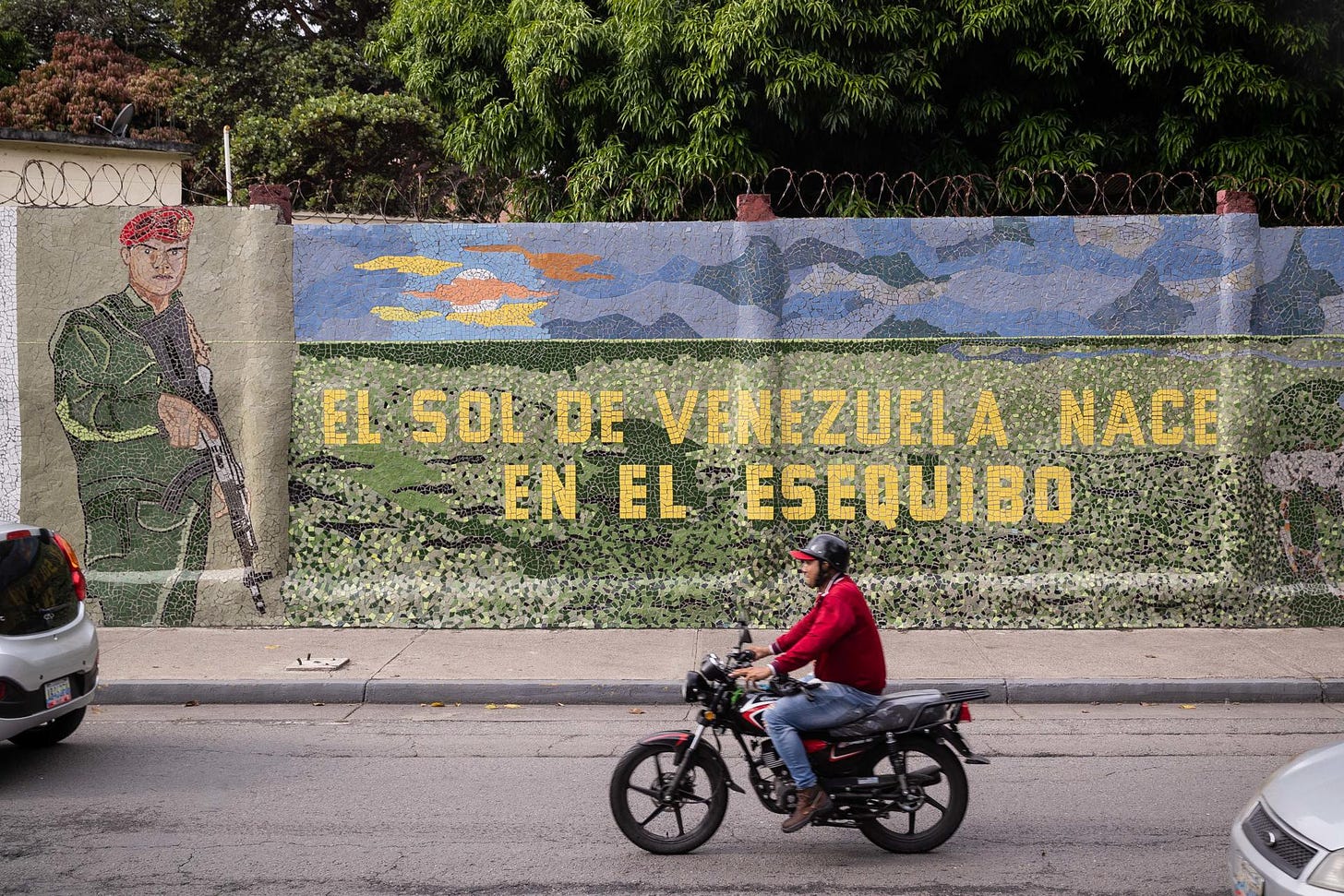 Un homme conduit une moto devant une fresque murale qui dit « le soleil du Venezuela est né par l'Essequibo », à Caracas, Venezuela, 2 novembre 2023. EFE/ Rayner Peña R.