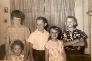 Barbara with her hands protectively on my shoulders, and other siblings Chris, Carla, John