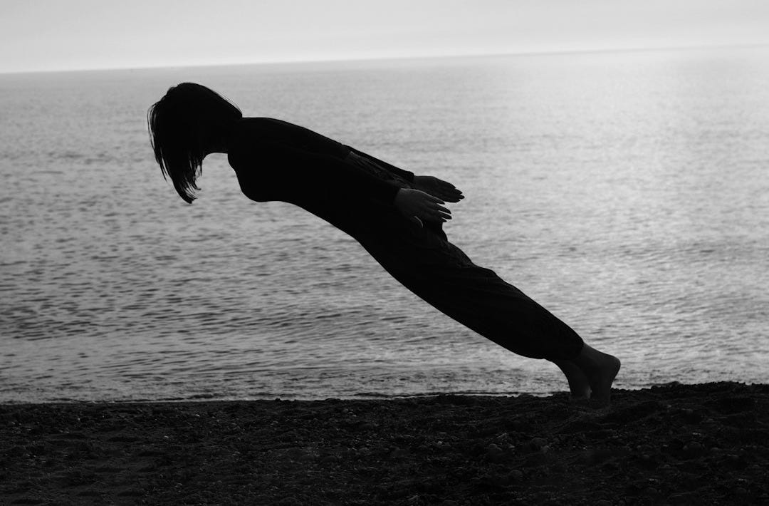 person doing gravity lean on the shore person doing gravity lean on the shore