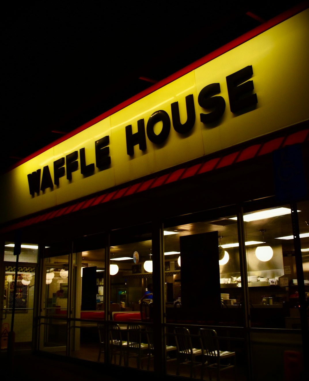 the front of a restaurant at night with a neon sign