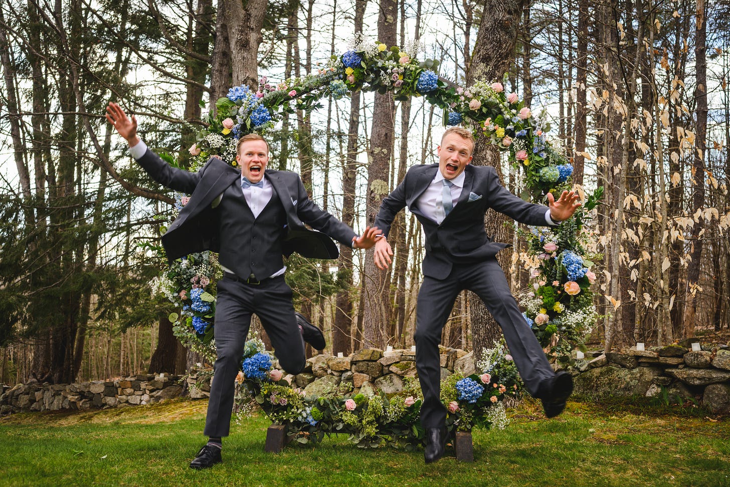 A groom and a groomsman leaping through the circular arbor