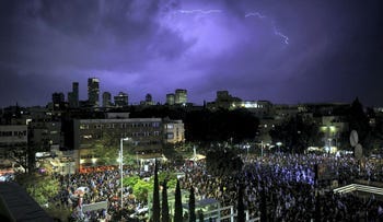 Lightning strikes as Israelis protest against Prime Minister Benjamin Netanyahu's new right-wing coalition and its proposed judicial reforms to reduce powers of the Supreme Court in a main square in Tel Aviv on Saturday.