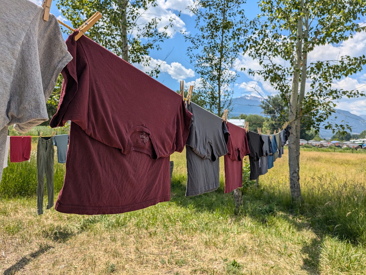 clothes on an outdoor clothesline in the sunshine with mountains and blue sky in the background