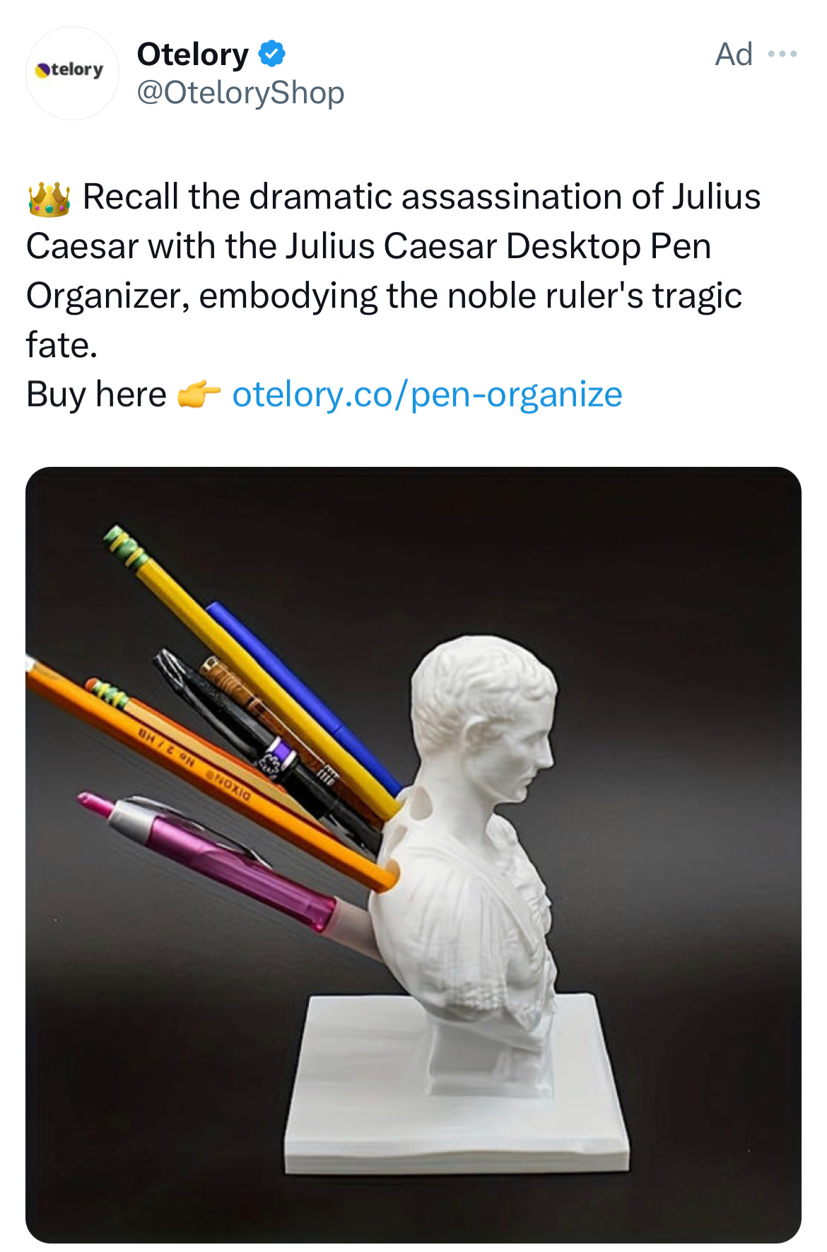 A Twitter ad from Otelory, a dropping shipping company saying "Recall the dramatic assassination of Julius Caesar with the Julius Caesar Desktop Pen Organizer, embodying the noble ruler's tragic fate." The image is of a white bust of Julius Caesar with pens and pencils stuck into the back of it.