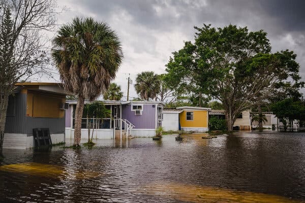 A flooded mobile home park under a cloudy sky.