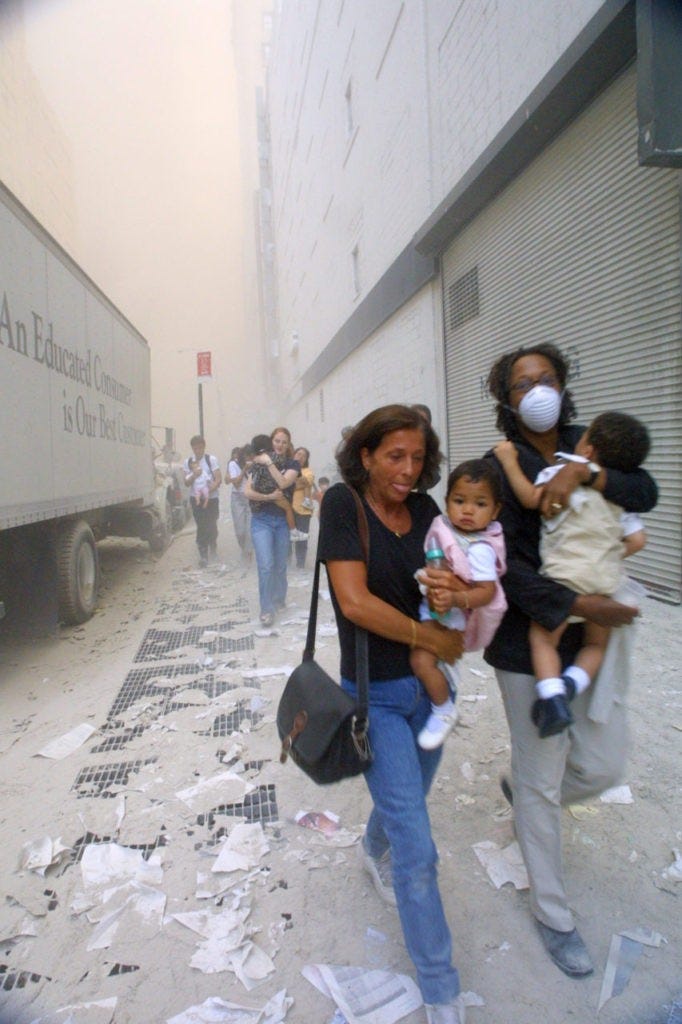 394261 40: People evacuate the area around the World Trade Center after it was hit by two planes September 11, 2001 in New York City. (Photo by Mario Tama/Getty Images)