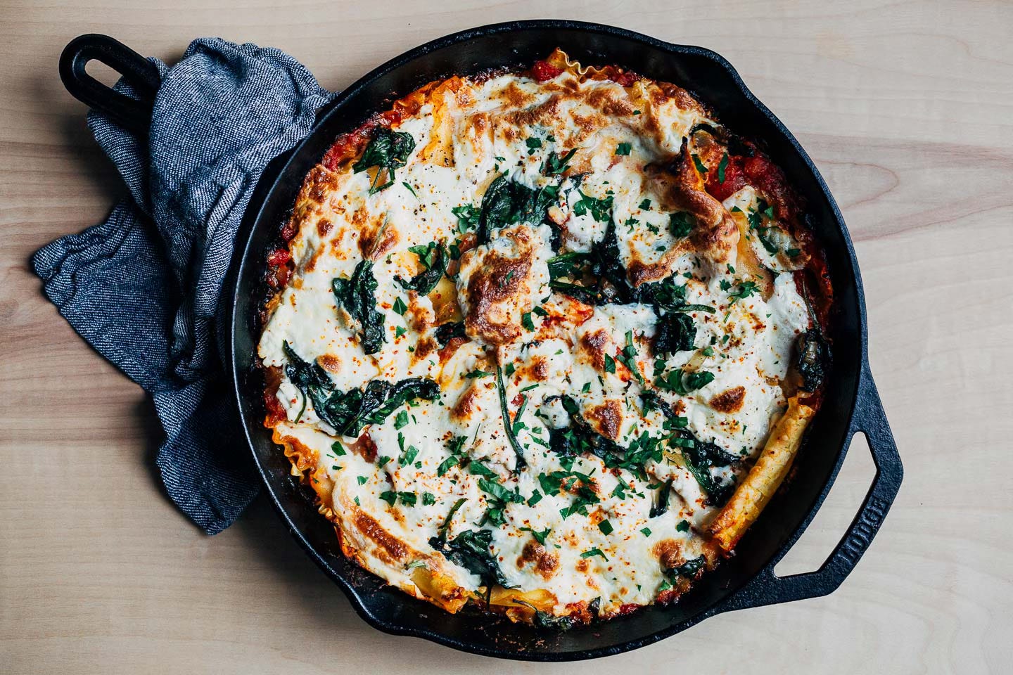 A cast iron skillet with baked lasagna