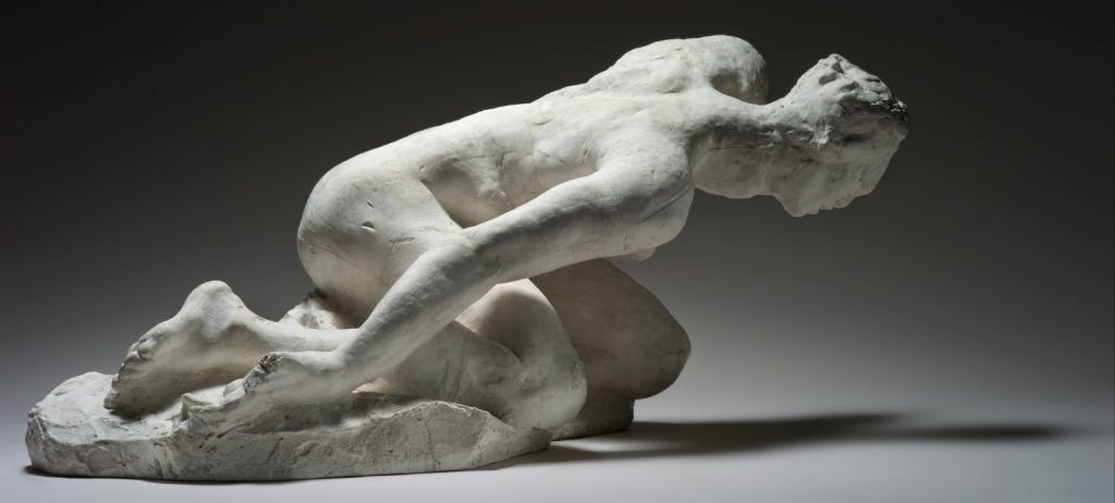 Auguste Rodin’s, The Tragic Muse, 1895. A plaster sculpture of a woman crouched with her knees on the ground, her legs under her, and feet behind, with her upper body leaning forward, low to the ground, and her arms extended back toward her feet. It is a very awkward, strained pose. Her neck is unusually long and unnaturally articulated. Her head faces down. The modeling is loose but lifelike, and while all the proportions except for her neck appear anatomically plausible, her pose is strange and pained. In this image, her right side is oriented toward the observer, with her feet at image left and her head extending to image right.