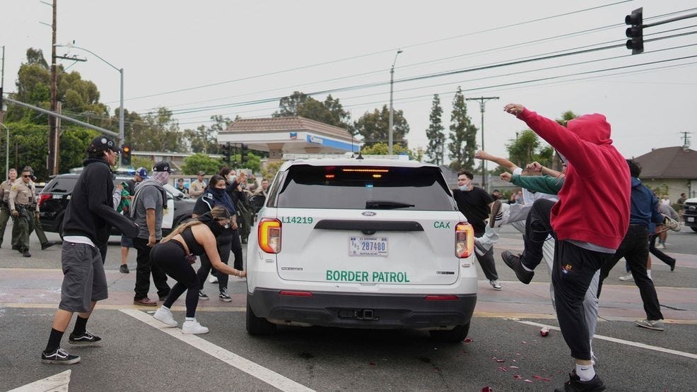 Protesters kick the side of a Border Patrol vehicle during a demonstration over the dozens detained in an operation by federal immigration authorities a day earlier, in Paramount, Calif., Saturday, June 7, 2025. (AP Photo/Eric Thayer)