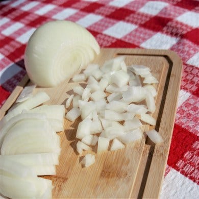 Fresh chopped onions on a cutting board, ready for to be added to Big Spoon's Fiesta Taco Soup.
