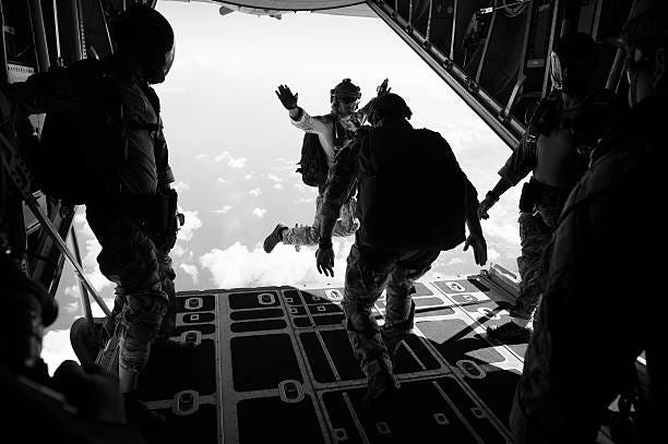 Explosive ordnance disposal EOD technicians assigned to Explosive Ordnance Disposal Mobile Unit EODMU 5 perform a free fall jump from a C-130...