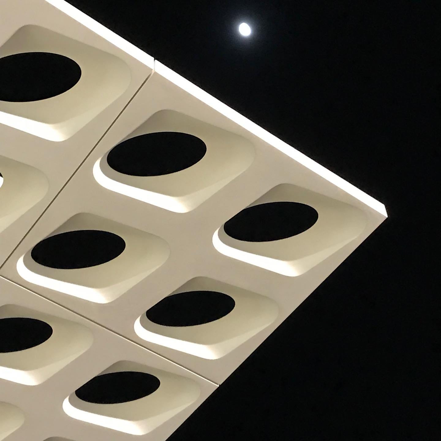 The roof of Apple Scottsdale Fashion Square from outside. The sky is black and the moon shines bright near the top of the frame.