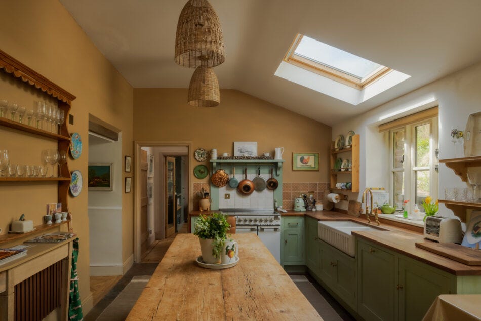 A sloping roof with skylight over a dining table in the middle of a country kitchen