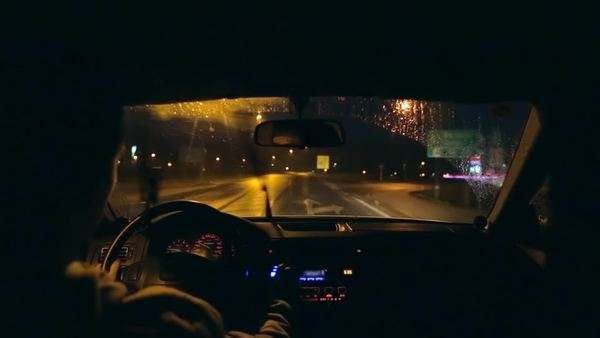 Male driving personal car on highway at night and rainy conditions ...