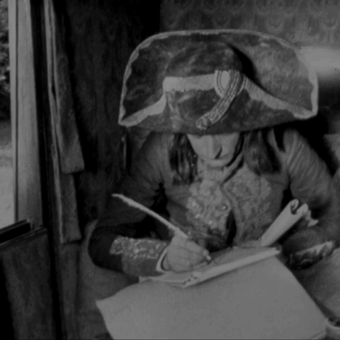 Animated gif - in Abel Gance’s 1927 film Napoleon, hastening to the Italian campaign by carriage, writes a note using a quill pen