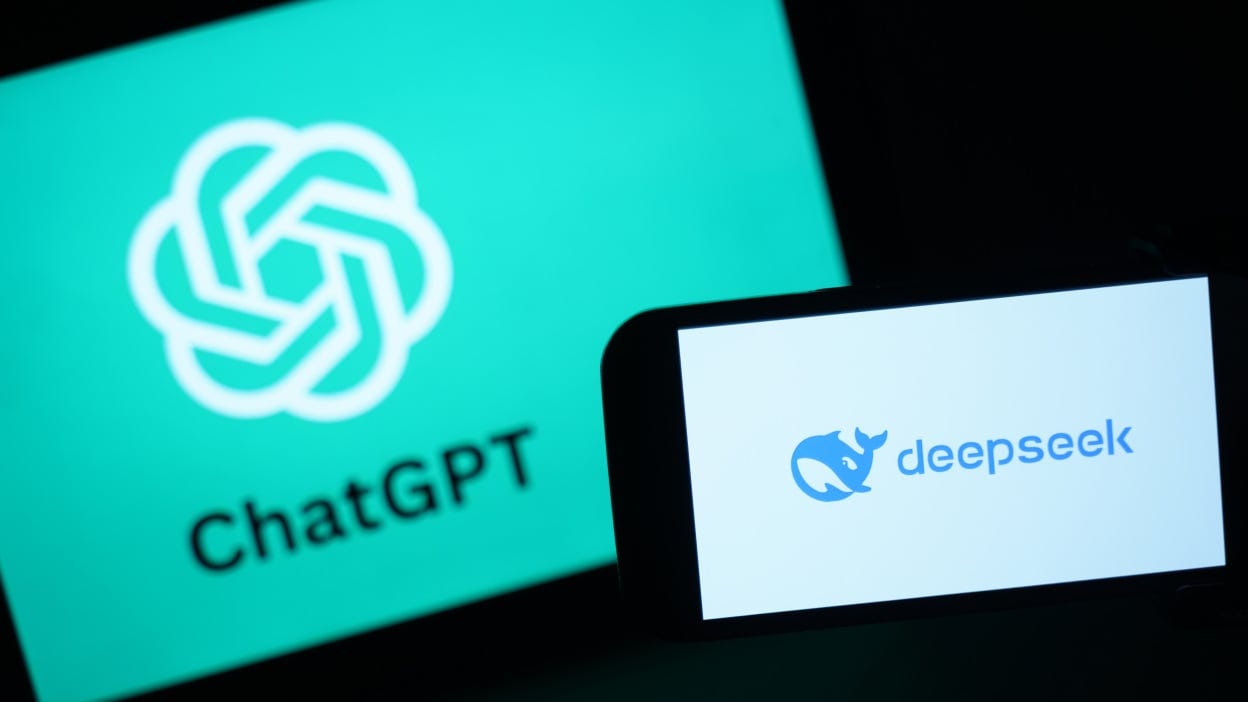 a phone with the deepseek logo in front of a screen with the chatgpt logo