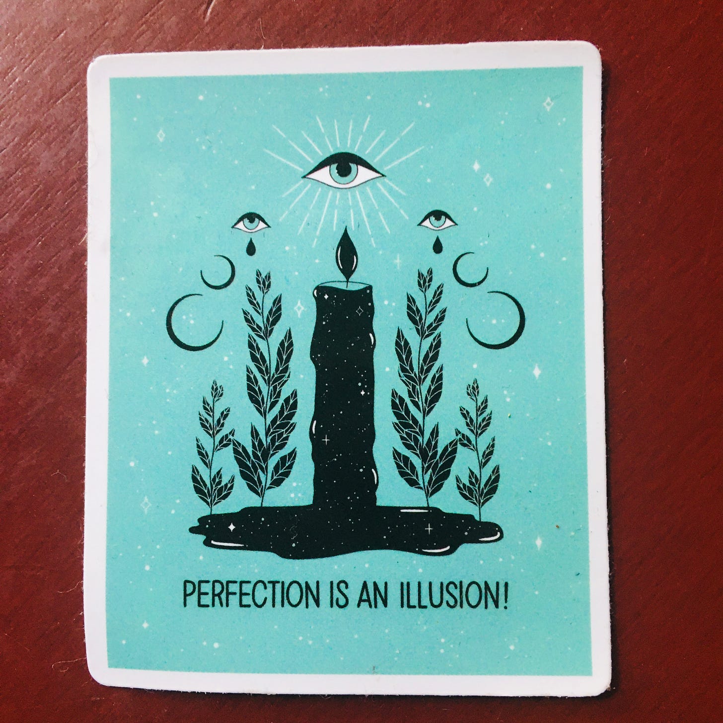 picture of a lit candle with an eye above it that says, PERFECTION IS AN ILLUSION!