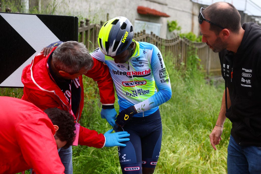 Team Intermarche's Eritrean rider Biniam Girmay (C) receives assistance after a fall during the 4th stage of the 107th Giro d'Italia cycling race, 190 km between Acqui Terme and Andora, on May 7, 2024 in Andora. (Photo by Luca Bettini / AFP)