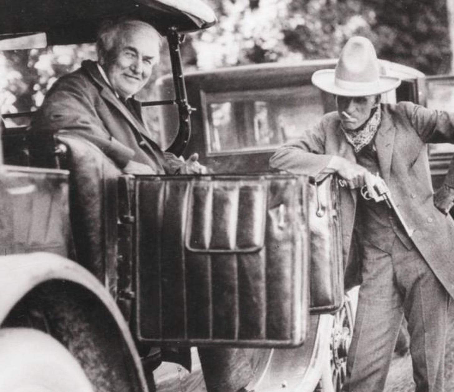 Thomas Edison and Henry Ford. Edison is sitting in the automobile while Ford leans on the door.Getty Images.