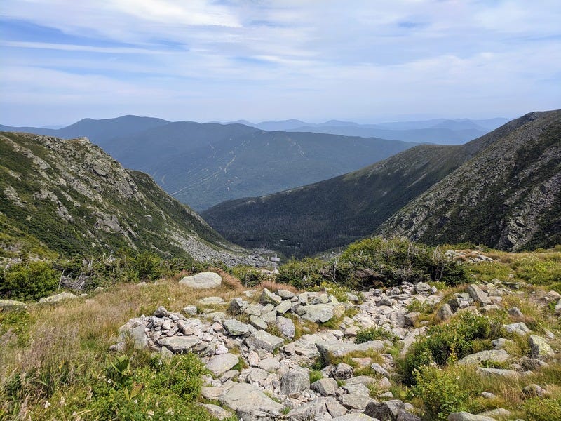 A photo high up on the mountain showing rocky ridges in the distance