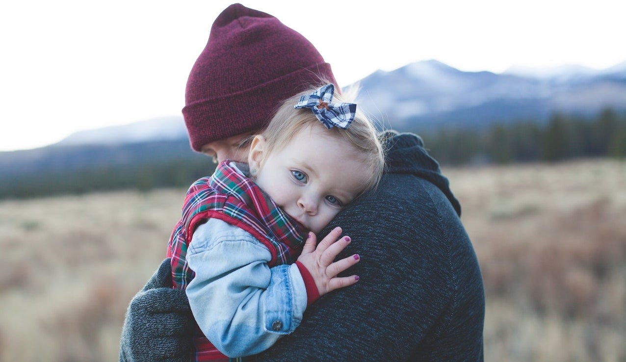 A father holding his young daughter