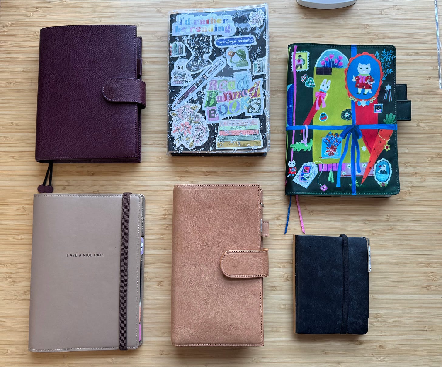 Six notebooks in planners on a desk; see caption for a description Six notebooks in planners on a desk; see caption for a description