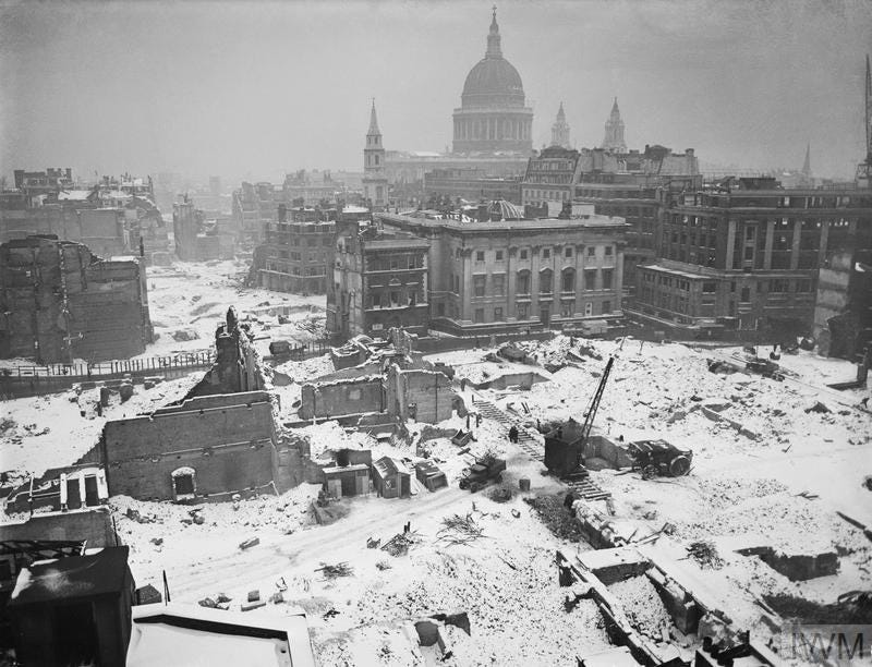 A black-and-white photograph of London after bomb damage, and under snow, with St. Paul's Cathedral in the distance