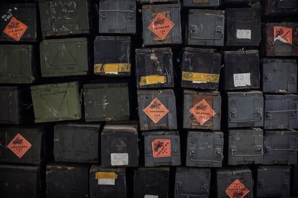 A wall of metal containers, some reading, “Explosives.”