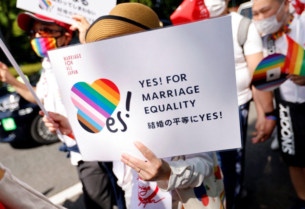 A participant holds a sign as they march during the Tokyo Rainbow Pride parade, celebrating advances in LGBTQ rights and c...