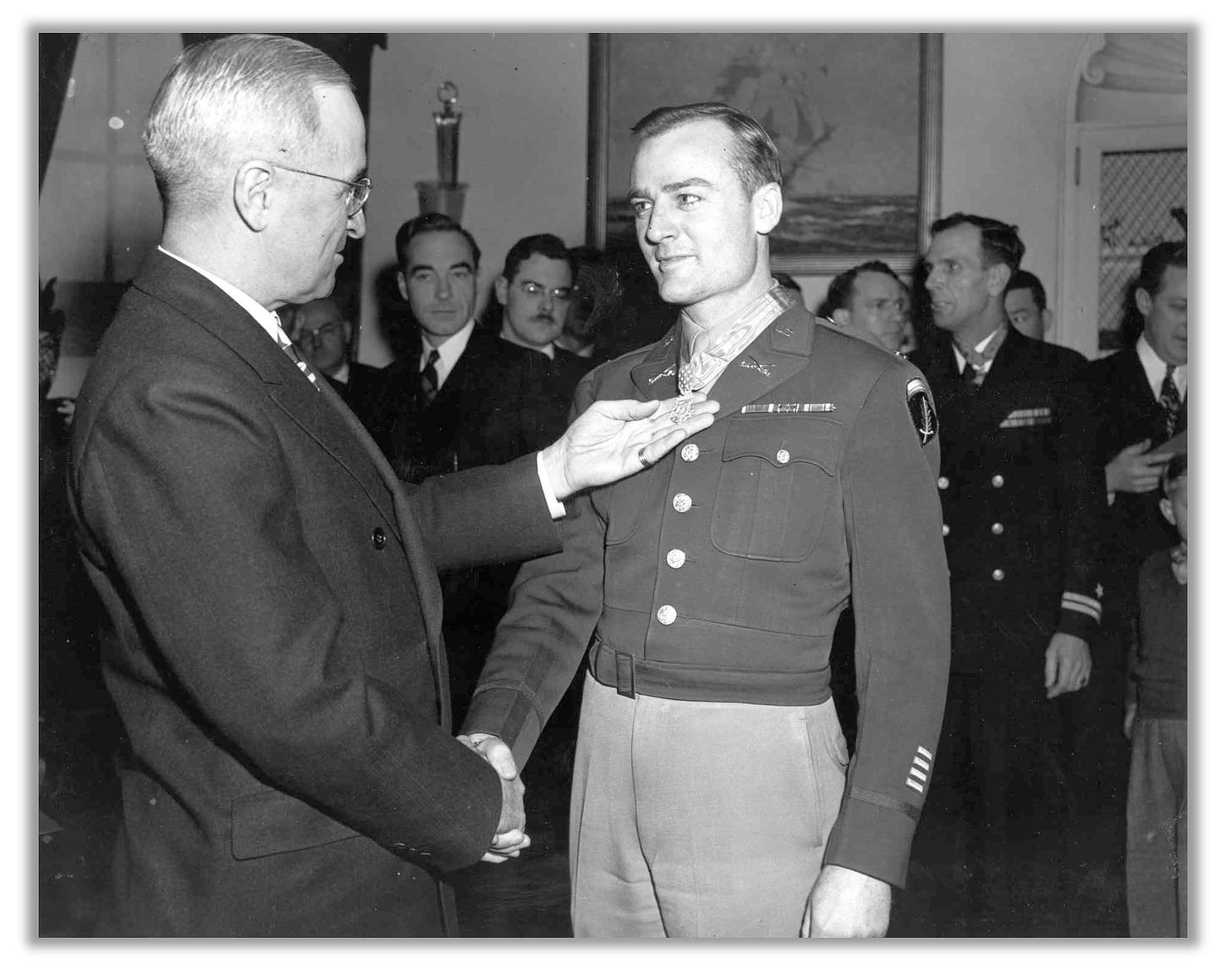 Lee receives the Medal of Honor from Truman. The two men are smiling.