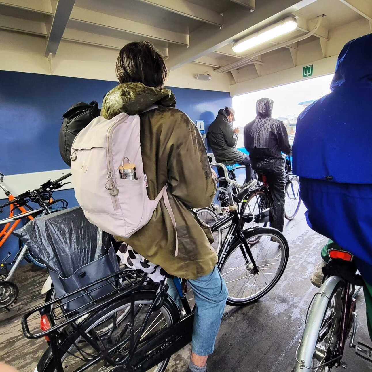 Photo of a group of cyclists waiting to ride off the ferry across the IJ in Amsterdam.