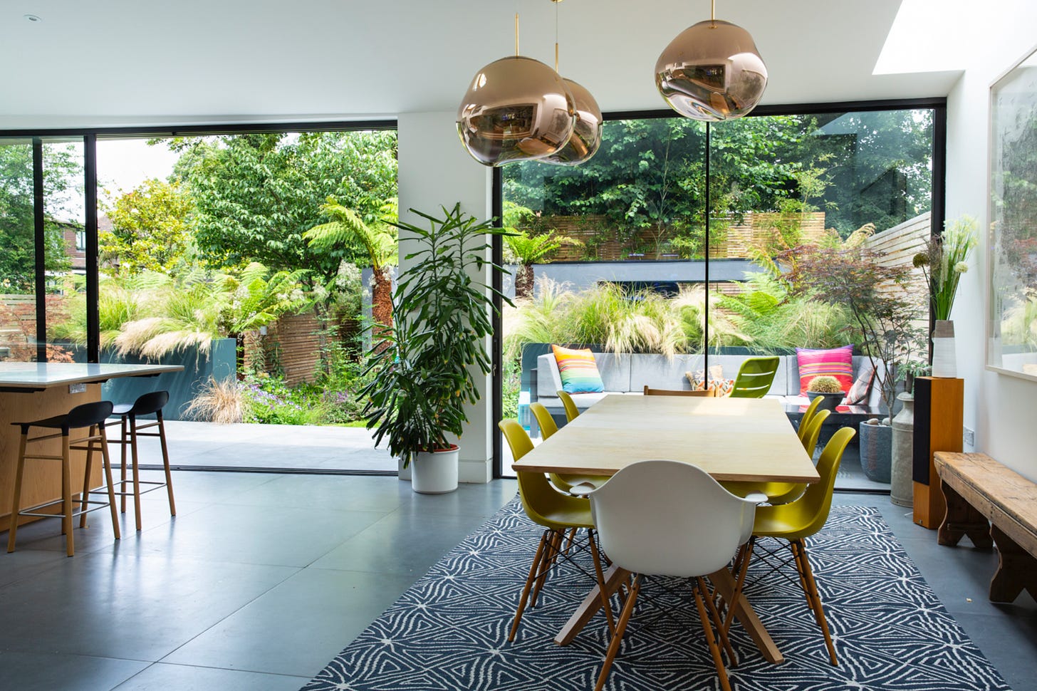 a contemporary interior looking out onto a small garden design from a kitchen and dining area inside the house